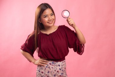 Bir büyüteç ile genç Asyalı kadın.