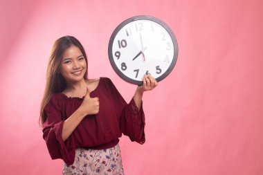 Genç Asyalı kadın başparmak yukarıya ile bir masa saati.