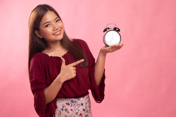 Joven asiática mujer punto a un reloj . —  Fotos de Stock