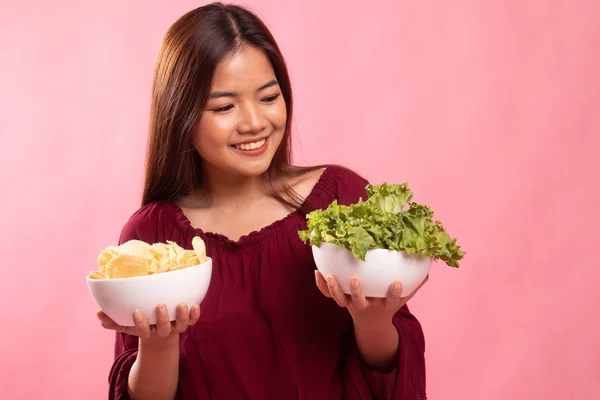 Giovane donna asiatica con patatine e insalata . — Foto Stock