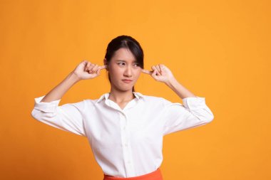 Genç Asyalı kadın parmakları ile her iki kulak engellemek.