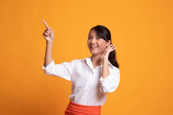 Opgewonden Aziatische vrouw punt aan lege ruimte. — Stockfoto
