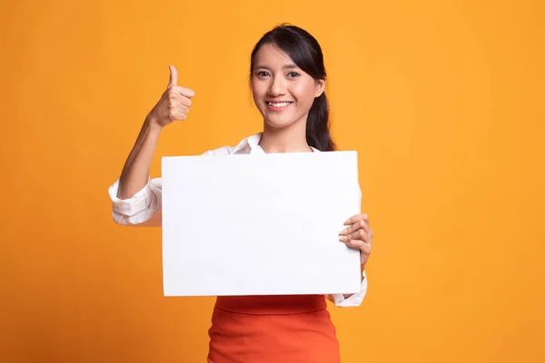 Jonge Aziatische vrouw opdagen duimen met witte leeg bord. — Stockfoto
