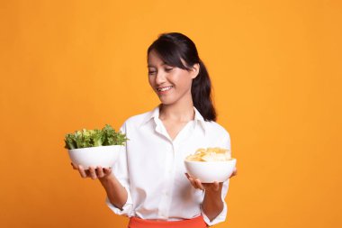 Patates kızartması ve salata ile genç Asyalı kadın.