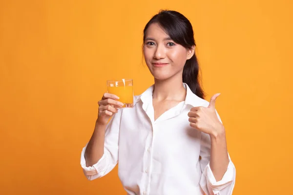 Jonge Aziatische vrouw duimschroef opwaarts drankje oranje sap. — Stockfoto