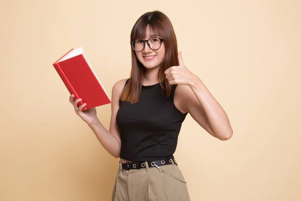 Ung asiatisk kvinna tummen upp med en bok. — Stockfoto