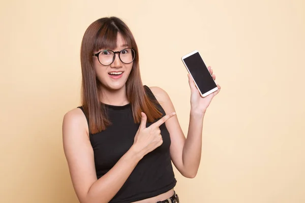 Aufgeregte junge Asiatin zeigt auf Handy. — Stockfoto