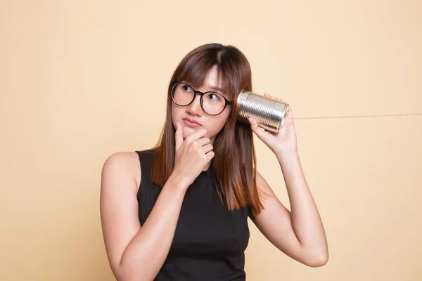 Jovem mulher asiática ouvir com lata pode telefone e pensar . — Fotografia de Stock