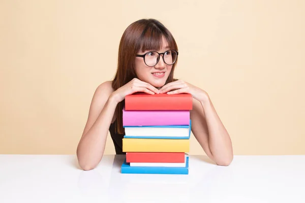 Happy young Asian woman read a book with books on table. — Stock Photo, Image