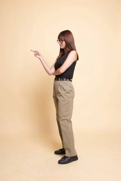 Full body side view of beautiful young asian woman pointing.