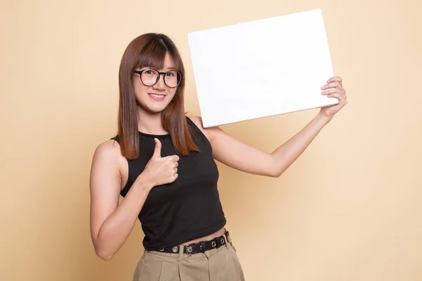 Jonge Aziatische vrouw opdagen duimen met witte leeg bord. — Stockfoto