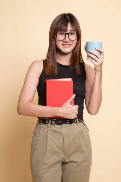 Jeune femme asiatique avec un livre et une tasse de café . — Photo