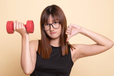 Dumbbells ile mutsuz Asyalı kadın başparmak aşağı.