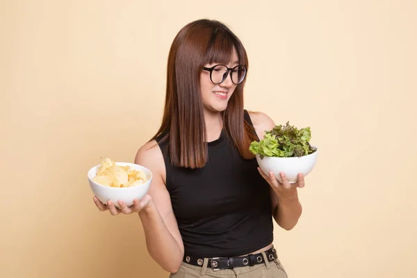 Jovem mulher asiática com batatas fritas e salada . — Fotografia de Stock