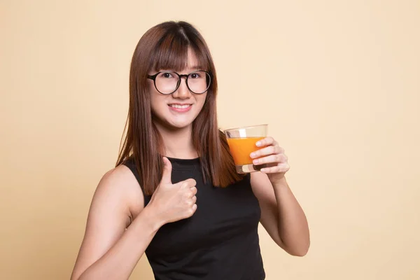 Jovem mulher asiática polegares até beber suco de laranja . — Fotografia de Stock