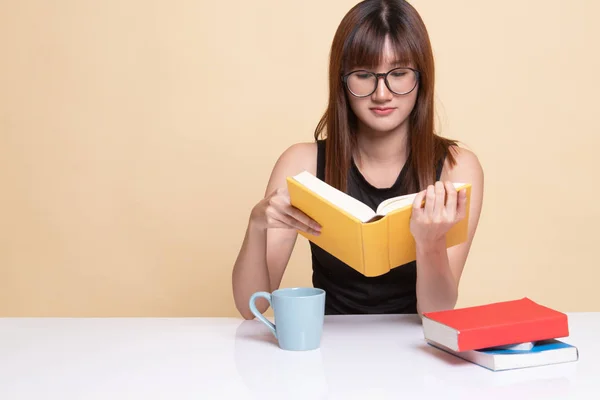 Ung asiatisk kvinna läsa en bok med kopp kaffe. — Stockfoto