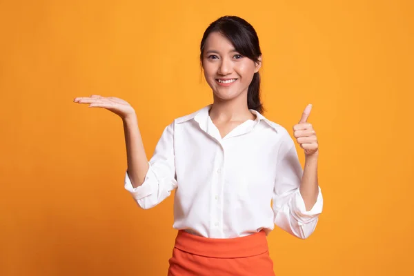 Beautiful young Asian woman show palm hand and thumbs up. — Stock Photo, Image