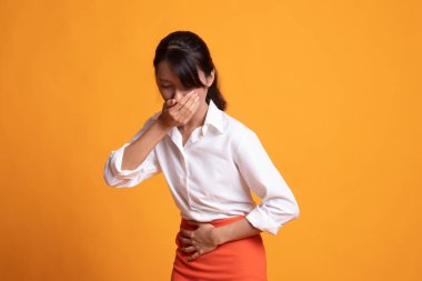 Genç Asyalı kadın yaklaşık kusma karın ağrısı var.