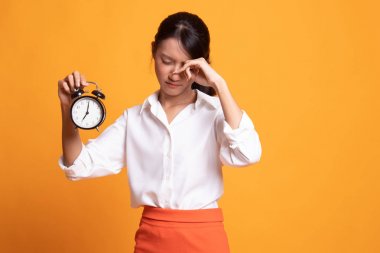 Sabah bir saat ile uykulu genç Asyalı kadın.