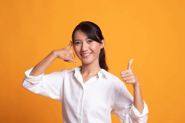 Young Asian woman thumbs up show with phone gesture.