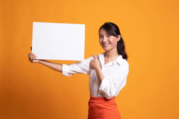 Jonge Aziatische vrouw opdagen duimen met witte leeg bord. — Stockfoto