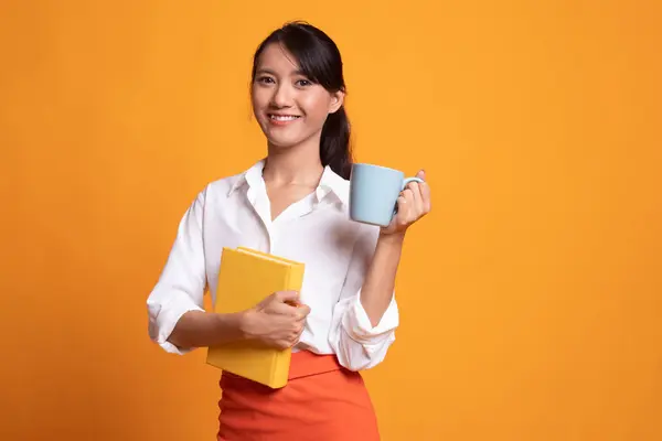 Junge asiatische Frau mit einem Buch und einer Tasse Kaffee. — Stockfoto