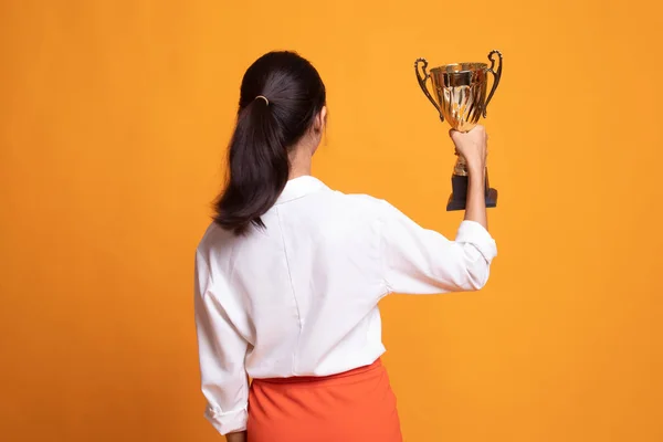 Vista posterior de la exitosa joven asiática sosteniendo un trofeo . — Foto de Stock