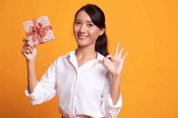 若いアジア女性は、ギフト ボックスが [ok] を表示します。. — ストック写真