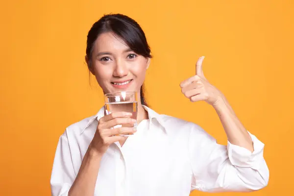 若いアジア女性の飲用水のガラスと親指. — ストック写真