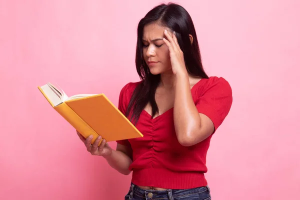 Joven asiática mujer got headache leer un libro . — Foto de Stock