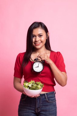 Saat ve salata ile genç Asyalı kadın.