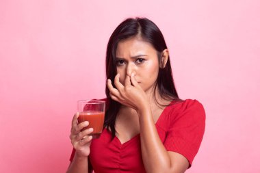 Genç Asyalı kadın nefret domates suyu.