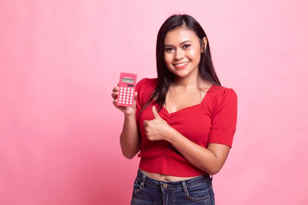 Asian woman thumbs up with calculator.