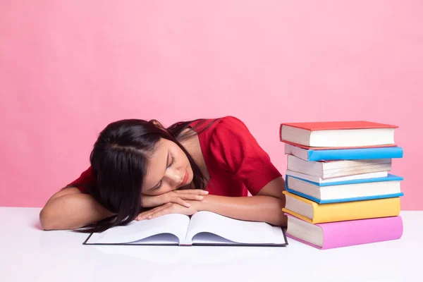 Esausto giovane donna asiatica dormire con libri sul tavolo . — Foto Stock