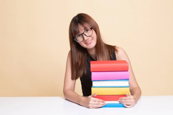 Happy young Asian woman read a book with books on table. — Stock Photo, Image