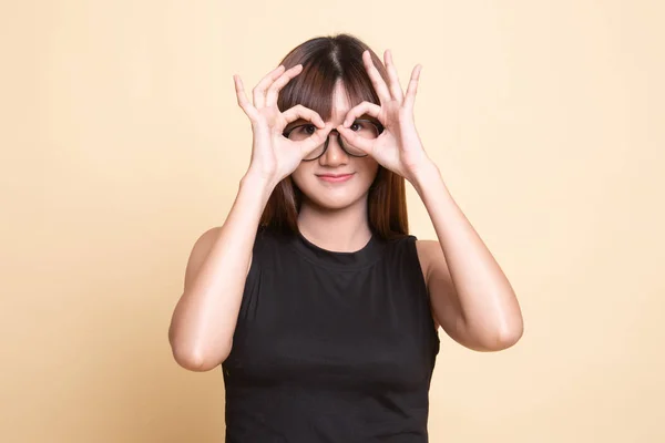 Asiatische Frau tun lustig doppelt ok Zeichen als Brille. — Stockfoto