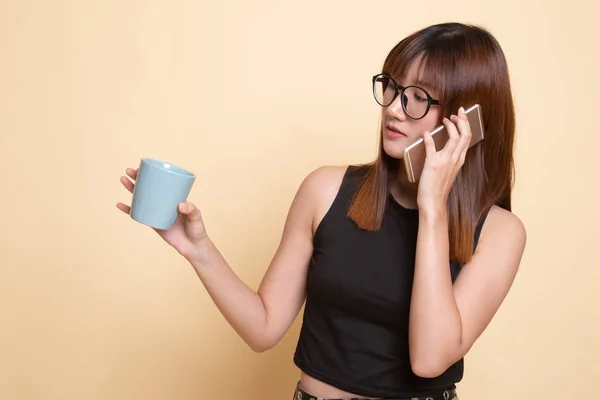 Jeune femme asiatique avec téléphone mobile et tasse de café . — Photo