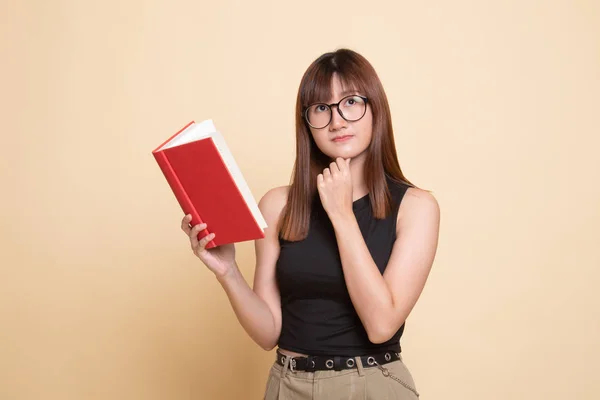 Young Asian woman with a book is thinking. — Stock Photo, Image