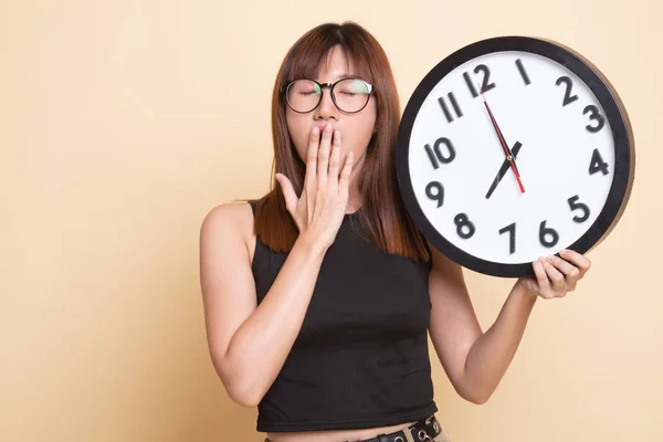 Somnolent jeune femme asiatique avec une horloge le matin . — Photo