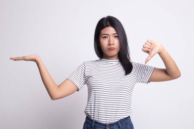 Genç Asyalı kadın göstermek palm el ve başparmak aşağı.