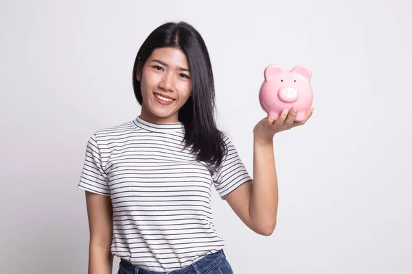 Jovem mulher asiática com um banco de moedas de porco . — Fotografia de Stock