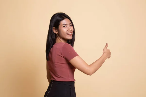 Ung asiatisk kvinna vända tillbaka tummen. — Stockfoto