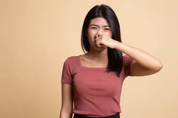 Joven asiática sosteniendo su nariz debido a un mal olor . —  Fotos de Stock