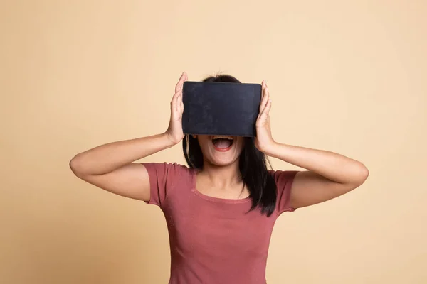 Young Asian woman with a computer tablet over her face. — Stock Photo, Image