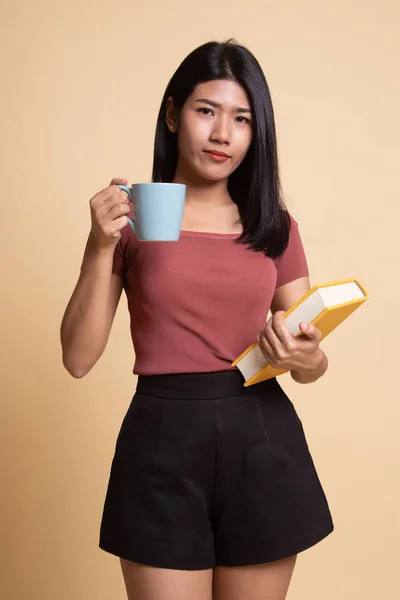 Jovem mulher asiática com um livro e xícara de café . — Fotografia de Stock