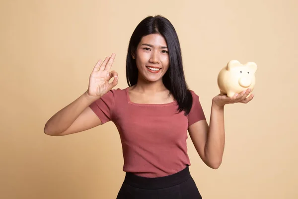Azjatyckie kobiety Pokaż Ok z pig monety bank. — Zdjęcie stockowe