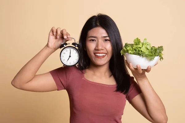 年轻的亚裔女子和时钟和沙拉. — 图库照片