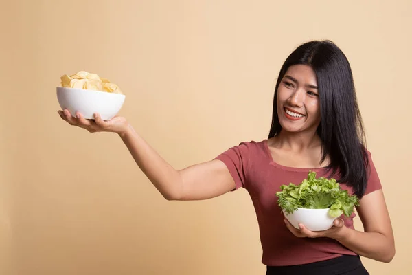 Ung asiatisk kvinna med potatischips och sallad. — Stockfoto