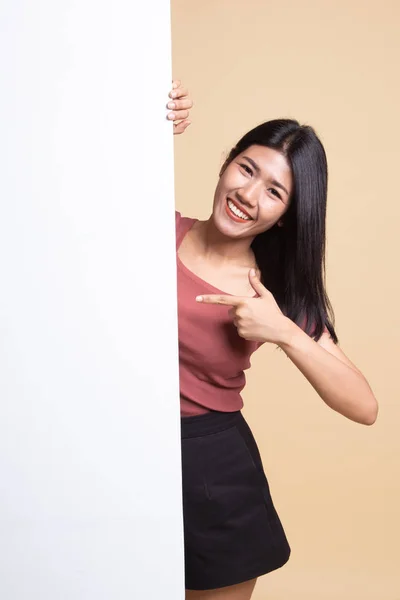 Young Asian woman point to a  blank sign.