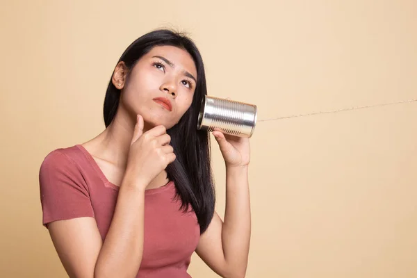 Jeune asiatique femme audition avec étain peut téléphone et penser . — Photo